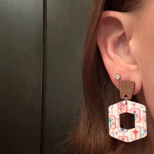 Model wearing Printed acrylic mahjong earrings showing colorful tile design paired with walnut wood trapezoid studs