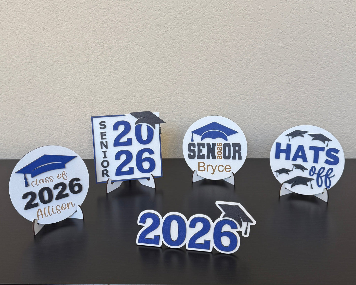 Half Turn Designs Class of 2026 High School Graduation Party decorations. Shown in white wood with blue accents. Available in 14 school colors.