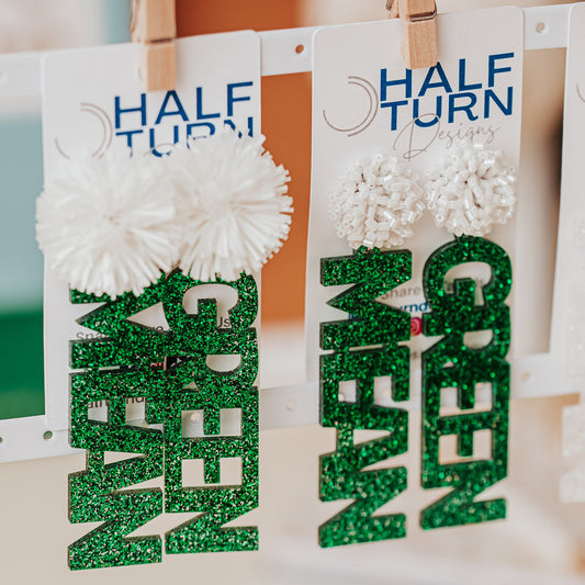 Officially licensed University of North Texas Mean Green Game Day earrings in green and white glitter with your choice of earrings topper including silver earring hooks, rhinestone topper, white tube bead topper, green tinsel topper, iridescent tinsel topper or white tinsel topper.