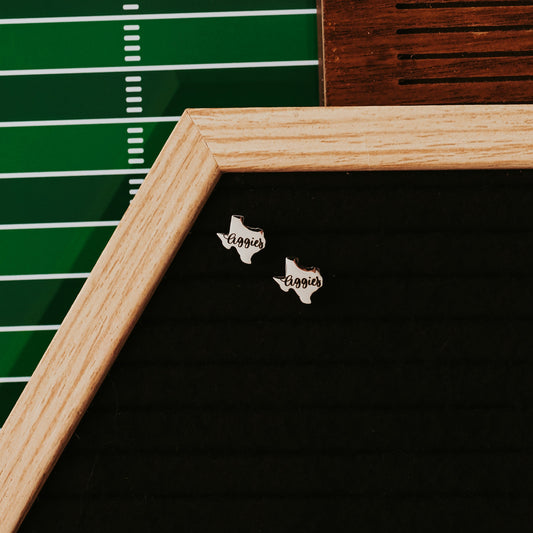Texas A&M Aggies Stainless Steel Earring Studs in the shape of the state of Texas in gold or silver finish by Half Turn Designs, officially licensed with Texas A&M University. Shown here in silver finish.
