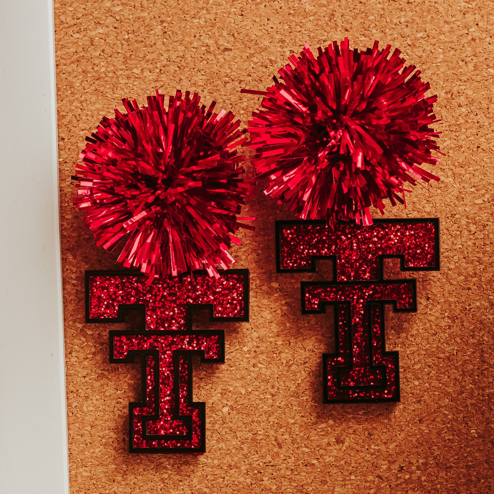 Red glitter Texas Tech Double T logo earrings with black acrylic accents shown with silver-tone stainless steel earring hooks. 