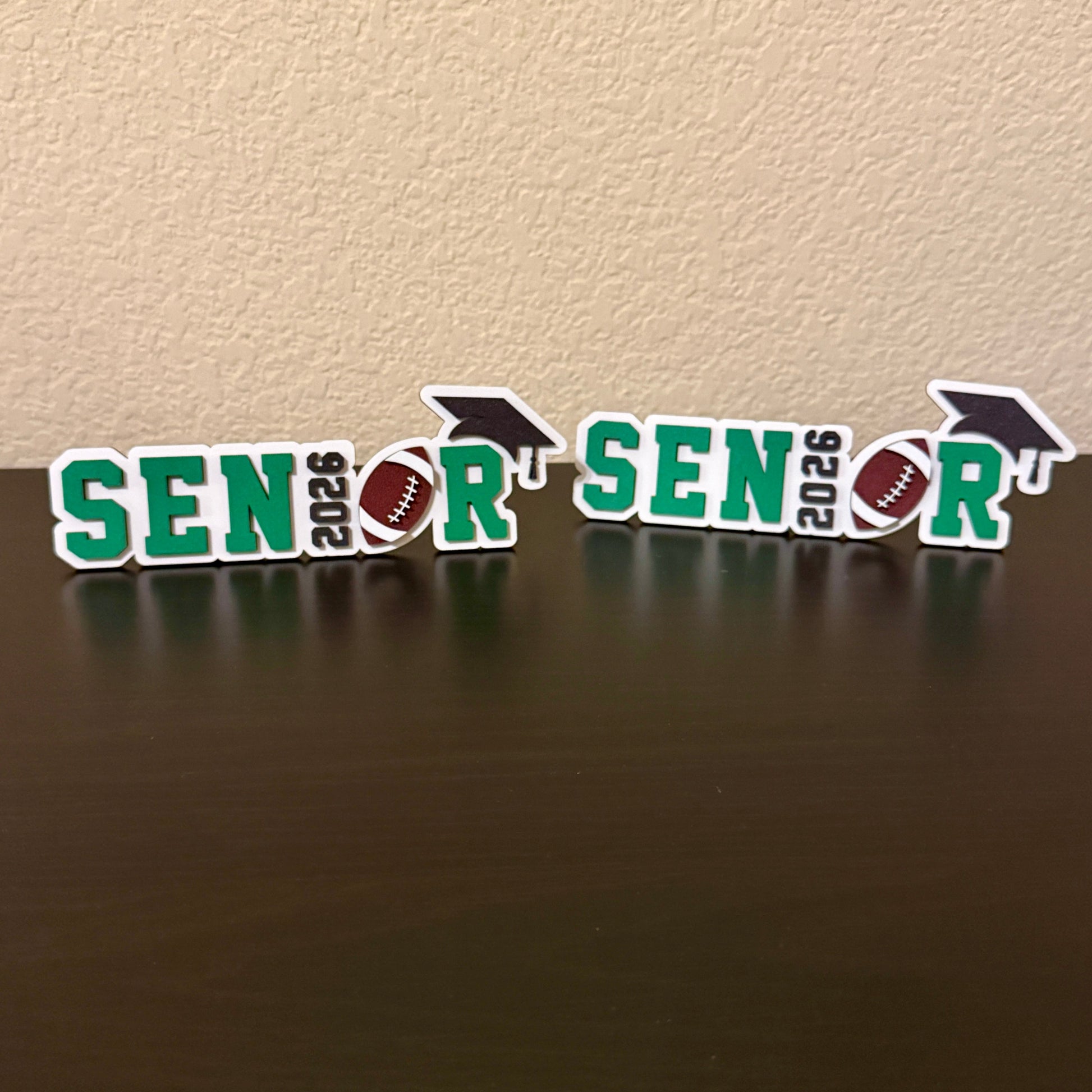 Two Class of 2026 football signs available in white wood shown with green accent colors.  
