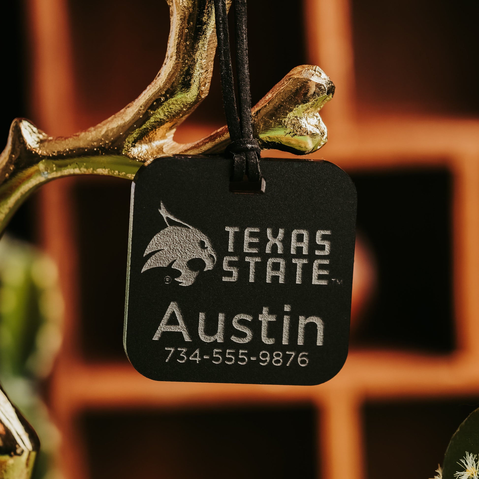 Personalized Texas State luggage tag in black acrylic, engraved with the Bobcat logo, a name, and phone number  