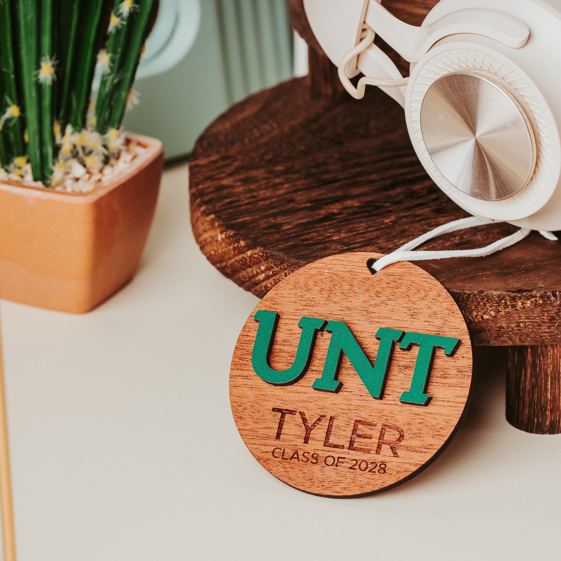 University of North Texas ornaments featuring green UNT letters with engraved personalization in mahogany. Officially licensed Mean Green personalized ornament by Half Turn Designs.