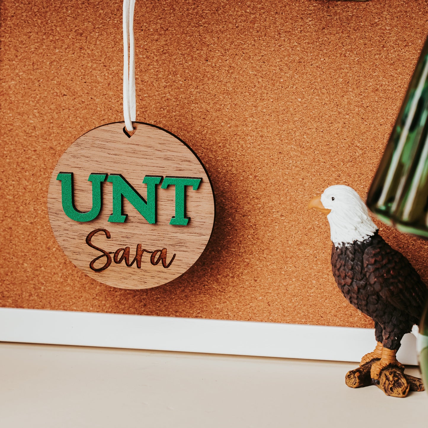 University of North Texas ornaments featuring green UNT letters with engraved personalization in walnut. Officially licensed Mean Green personalized ornament by Half Turn Designs.