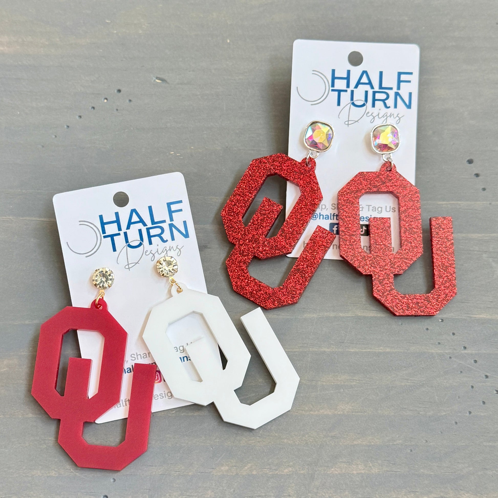 University of Oklahoma OU Game Day Dangle acrylic earrings. Officially Licensed Oklahoma Sooners jewelry by Half Turn Designs.
From left to right - 
- Crimson and white acrylic with rhinestone earring topper- White acrylic with crimson beaded toppers
- Crimson glitter acrylic with AB iridescent square jewel topper