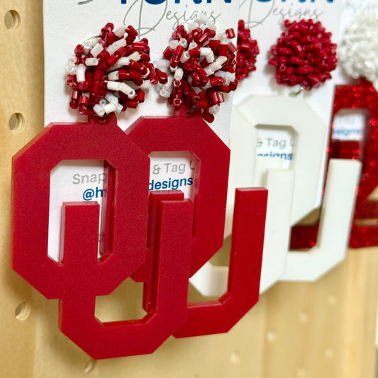 OU Game Day Dangle acrylic earrings in crimson acrylic with crimson and white bead earring toppers. Officially Licensed University of Oklahoma Boomer Sooner earrings by Half Turn Designs.