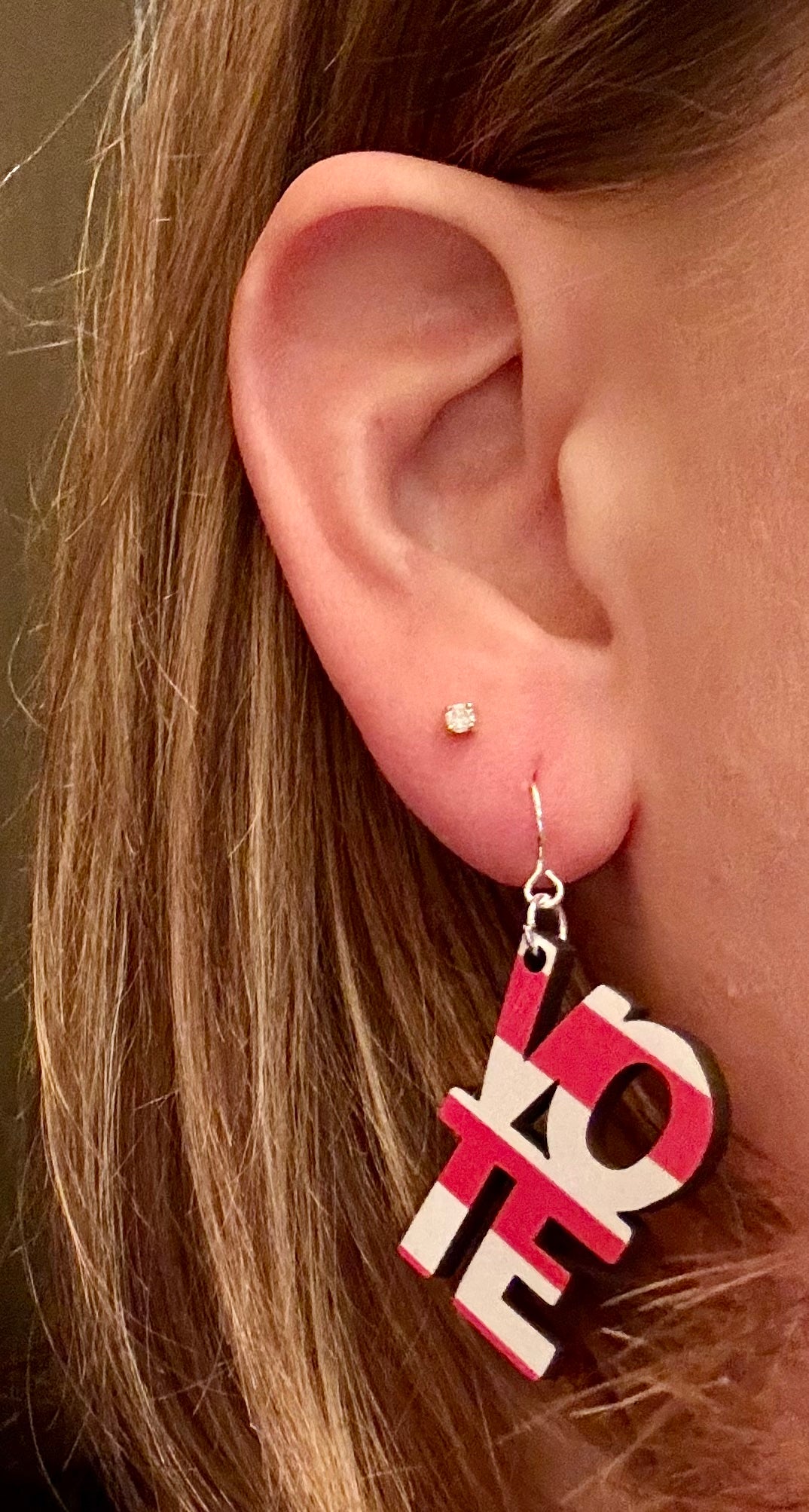 Model wearing patriotic Vote earrings in American flag design, handmade lightweight wooden jewelry for Election Day and voting