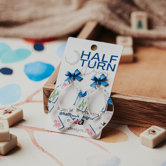 Blue Mahjong bow earrings in clear acrylic with 2 inch drop length