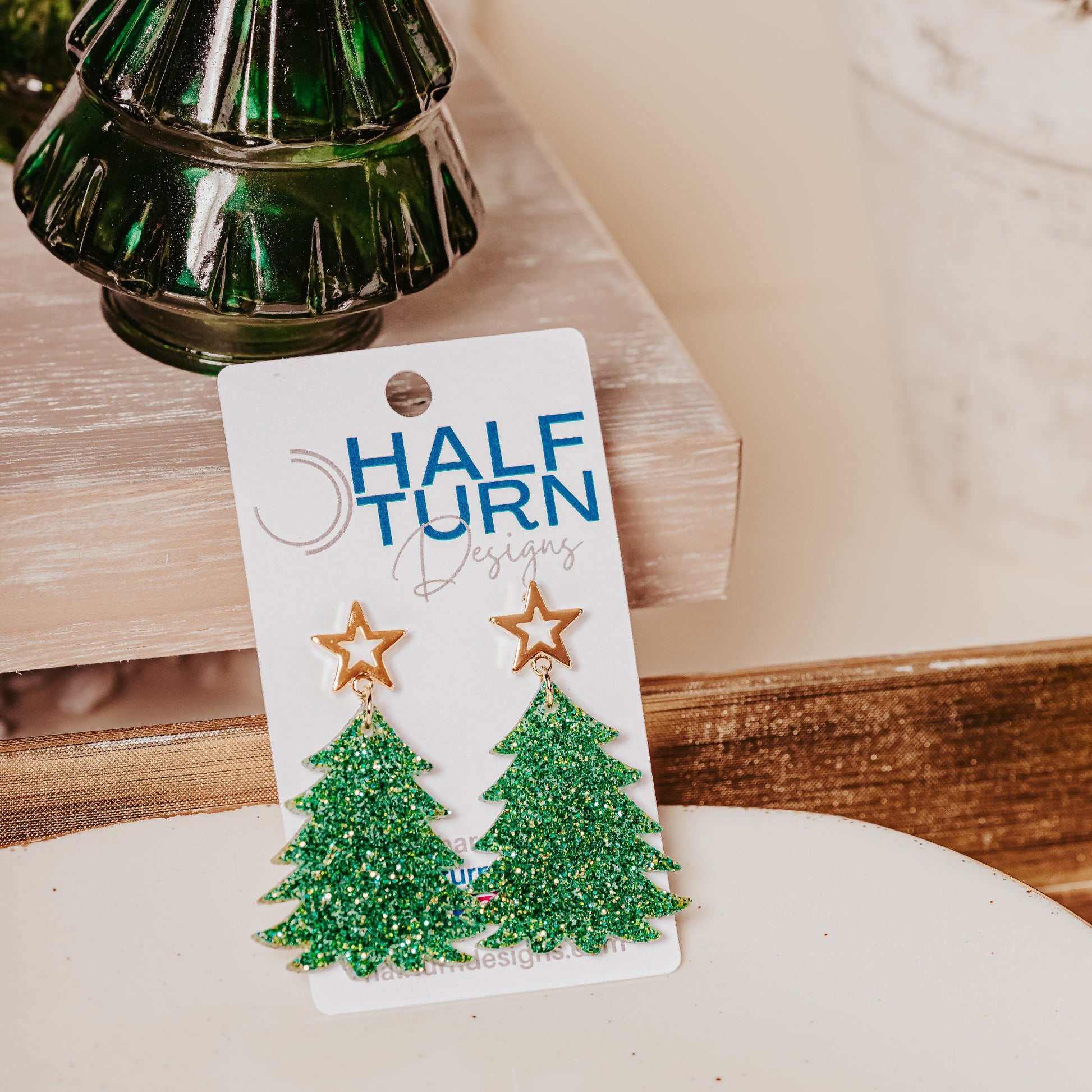 Green and gold glitter acrylic Christmas tree earrings with gold star studs showing sparkling festive dangle design on Half Turn Designs earring card