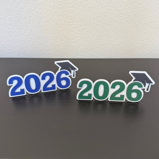 Class of 2026 high school graduation decor wooden signs with graduation cap detail, shown in green and blue school colors, perfect for senior parties and gift tables.  Available in 14 school colors