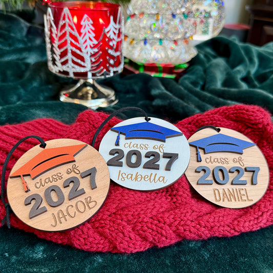 Class of 2027 ornaments in mahogany, white and cherry finish