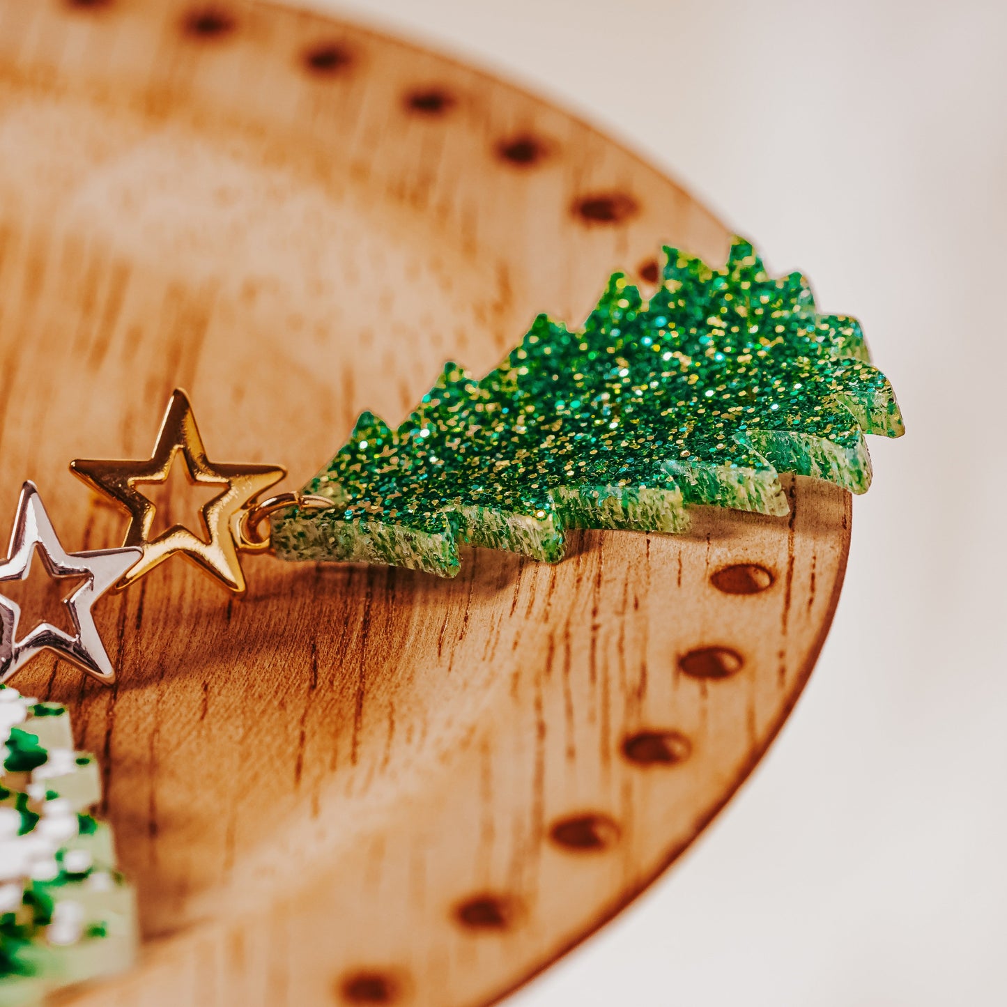 Green and gold glitter acrylic Christmas tree earrings with gold star studs showing sparkling festive dangle design by Half Turn Designs