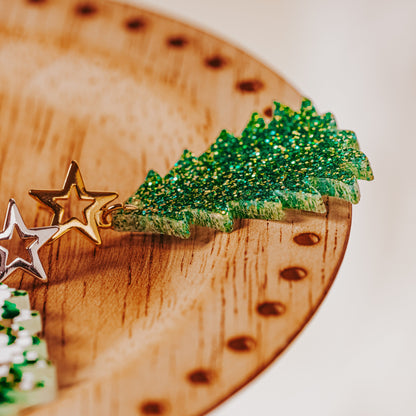 Green and gold glitter acrylic Christmas tree earrings with gold star studs showing sparkling festive dangle design by Half Turn Designs