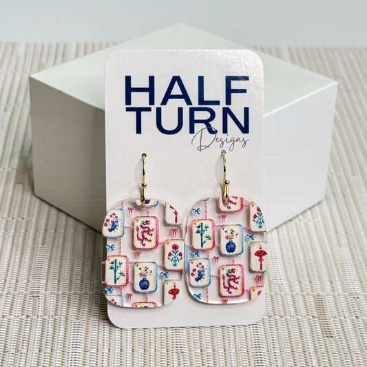 Rounded rectangle mahjong tile earrings made from clear acrylic with colorful tile illustrations and gold or silver stainless steel hooks