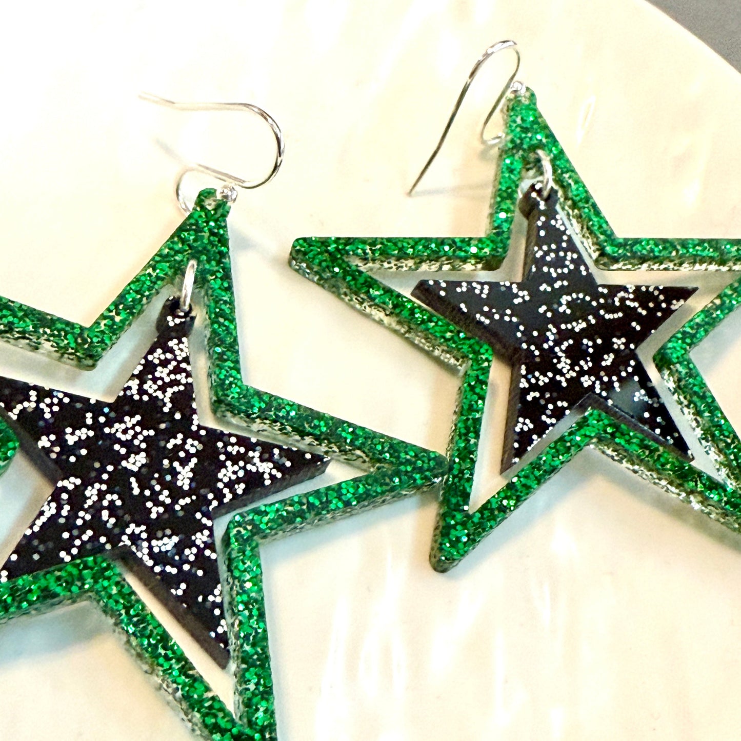 Green and black glitter stars earrings on silver hooks, lightweight acrylic dangles for game day, handmade in Texas by half turn designs