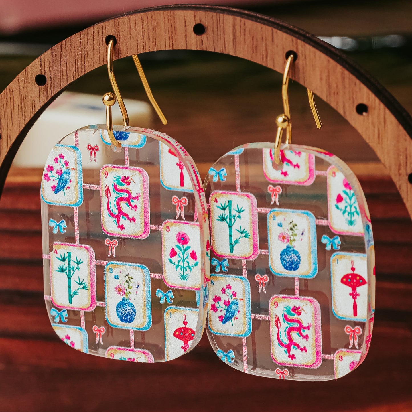 Lightweight mahjong tile dangle earrings in a rounded rectangle shape with multicolor tile artwork on clear acrylic