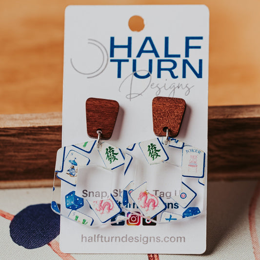 Hexagon-shaped mahjong earrings made from lightweight blue chinoiserie printed acrylic with hollow center and walnut wood trapezoid studs by Half Turn Designs