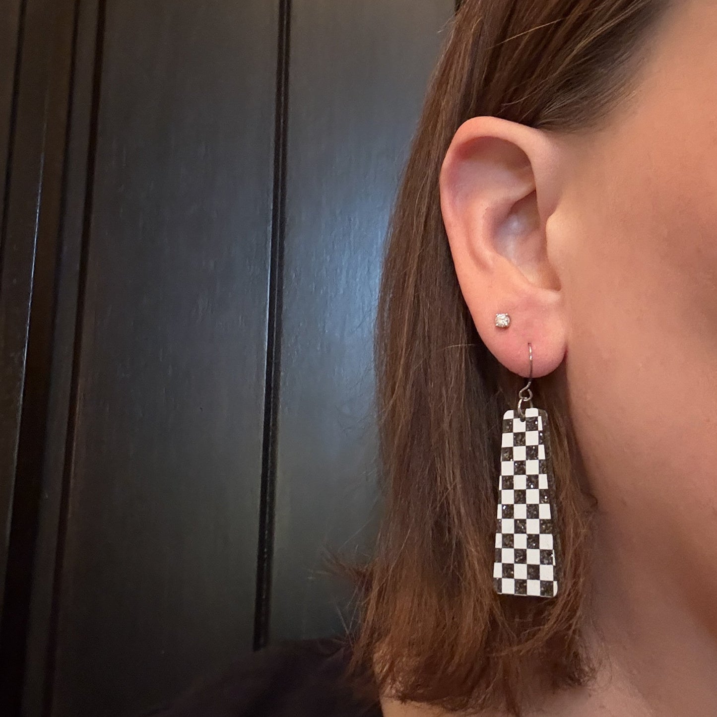 Model wearing Black and White Checkered Dangle Earrings with silver-toned earring hooks
