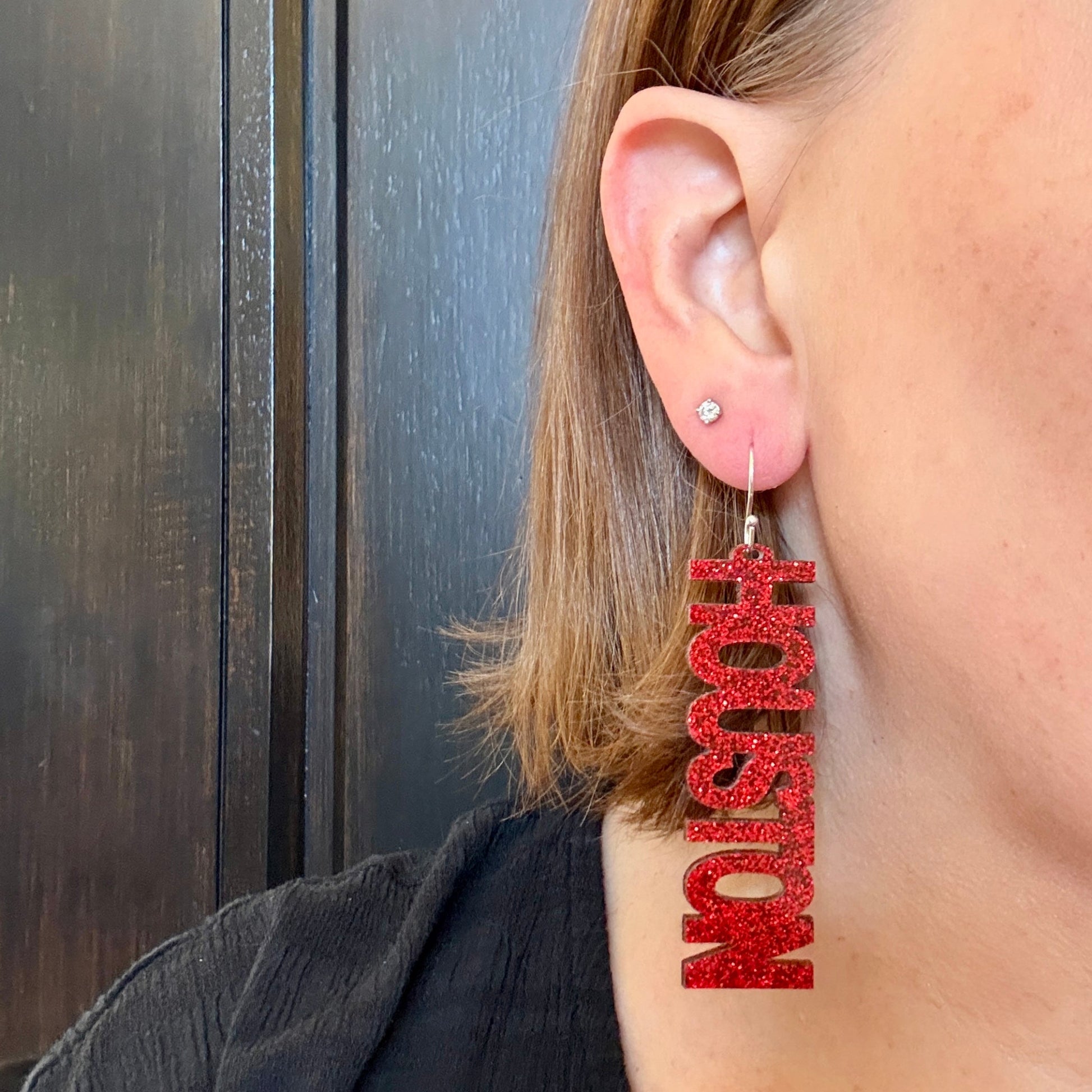 Model wearing University of Houston red glitter dangle earrings with stainless steel silver earrings