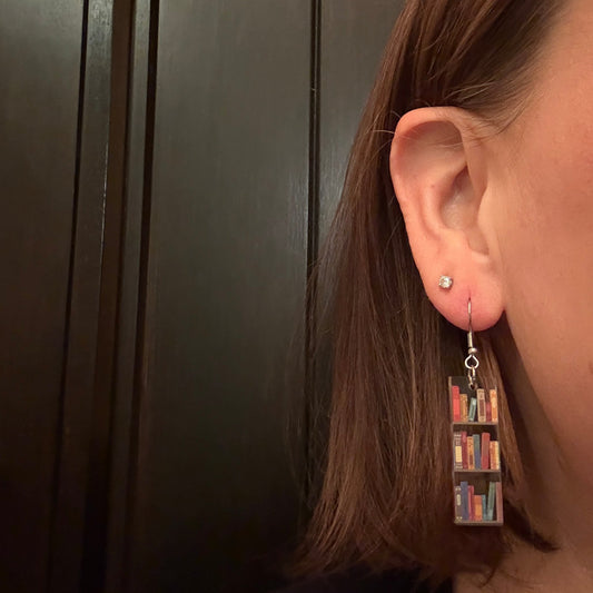 Model wearing Colorful mini bookshelf earrings made from clear printed acrylic with gold stainless steel hooks, perfect for book lovers