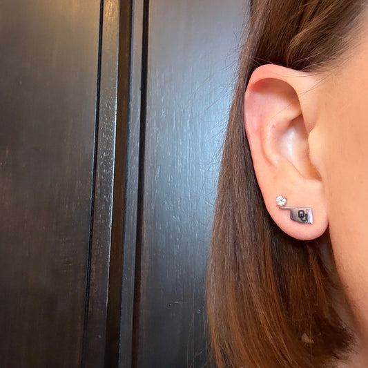 Model wearing Officially licensed University of Oklahoma hypoallergenic stainless steel earring studs in gold or silver tones.