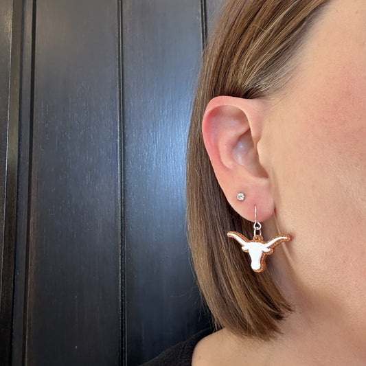 Model wearing University of Texas Longhorn Dangle earrings in white and burnt orange glitter with silver earrings hooks