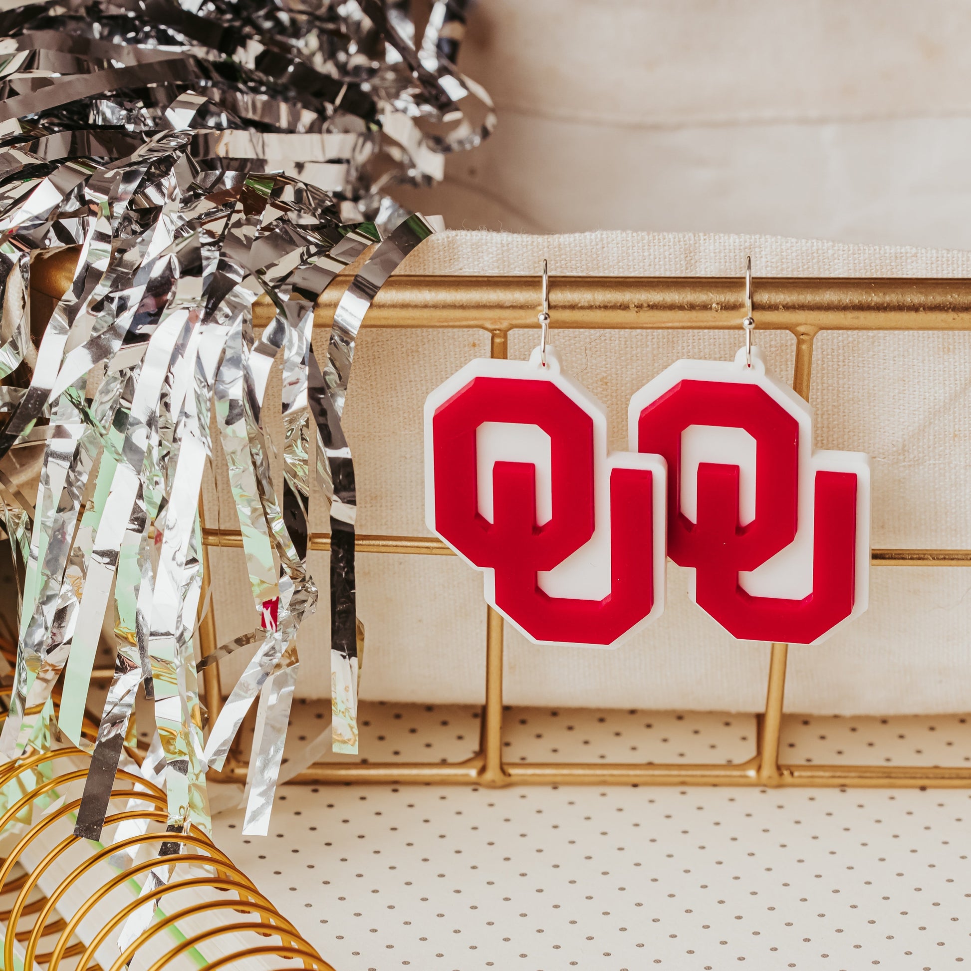 Officially licensed University of Oklahoma game day earring collection by Half Turn Designs. These earrings are available in combinations of crimson and white acrylic, including glitter. Available in a eight different fun toppers for OU game days and as a gift for your favorite Oklahoma Sooner. Crimson on White with silver earring hooks shown here.