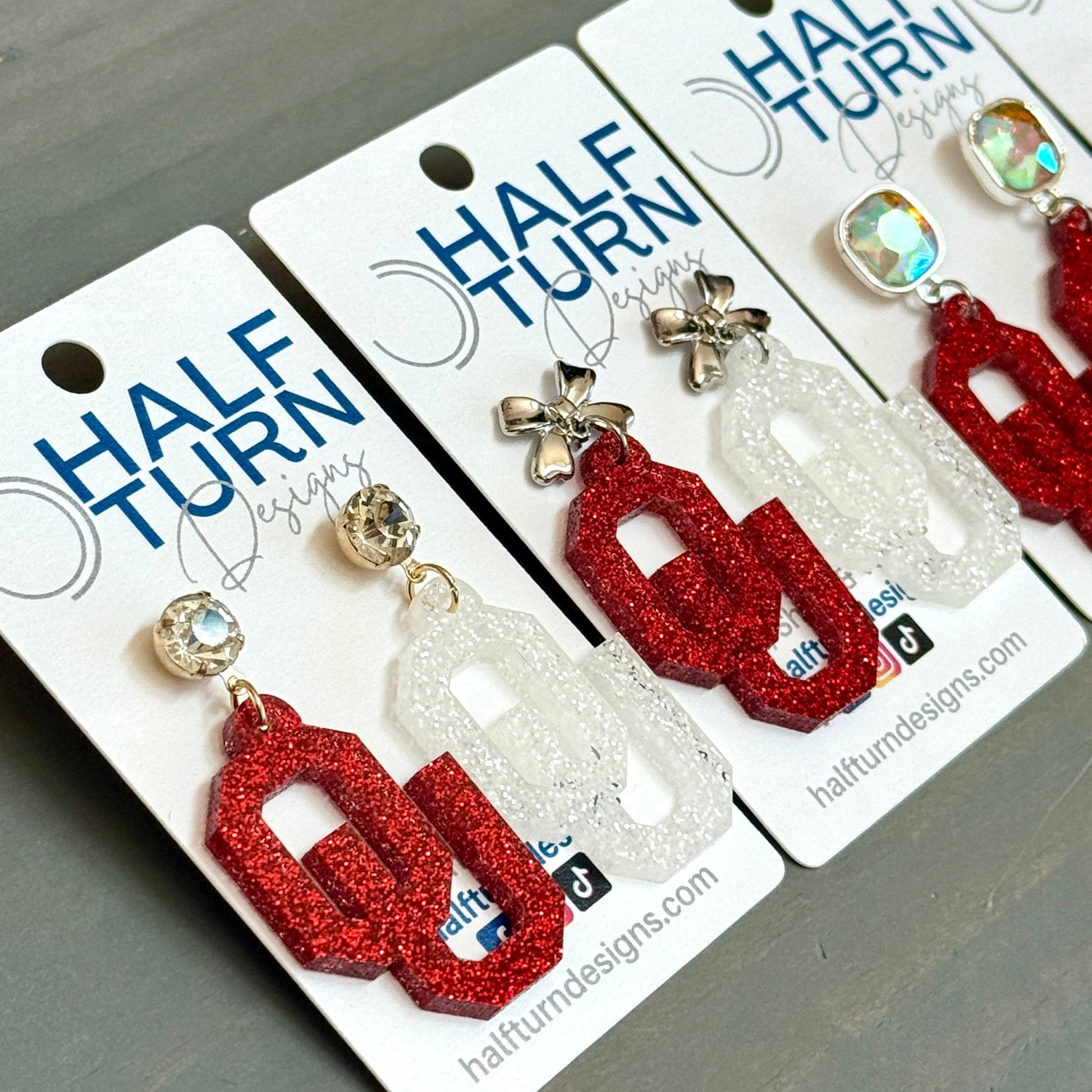 Officially Licensed University of Oklahoma Sooners Earrings in Crimson and White Glitter Acrylic, OU logo Boomer Sooner Game Day Jewelry for Students & Alumni in a variety of earring toppers including AB Iridescent Jewel, Rhinestone, Bows or Earring Hooks - all available in gold or silver finish.