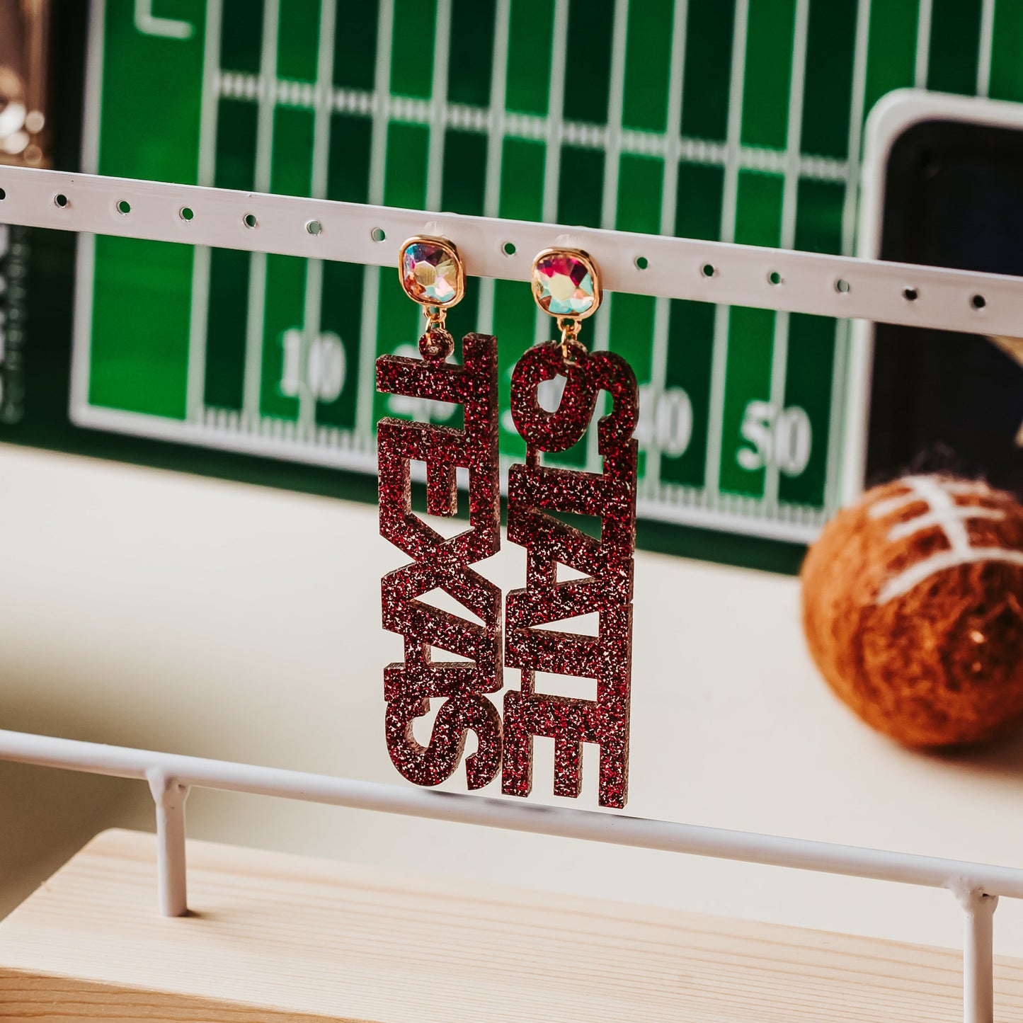 Official Texas State fan jewelry with seed bead, tinsel, hook, and jewel toppers, shown here with AB iridescent jewel topper in maroon glitter acrylic