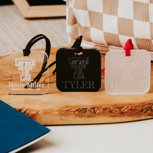 Officially Licensed Texas Tech University luggage tags featuring the TTU logo, personalized with customer's choice of 1-3 lines of information. Available in Clear, Frosted and Opaque Black acrylic by Half Turn Designs.