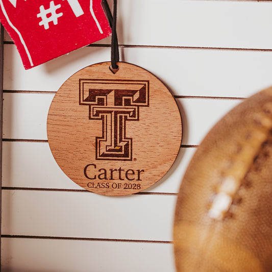 Officially Licensed Texas Tech University round wooden ornament with engraved TTU logo and 1-2 lines of personalized text. Available in cherry, mahogany or white wood finishes.