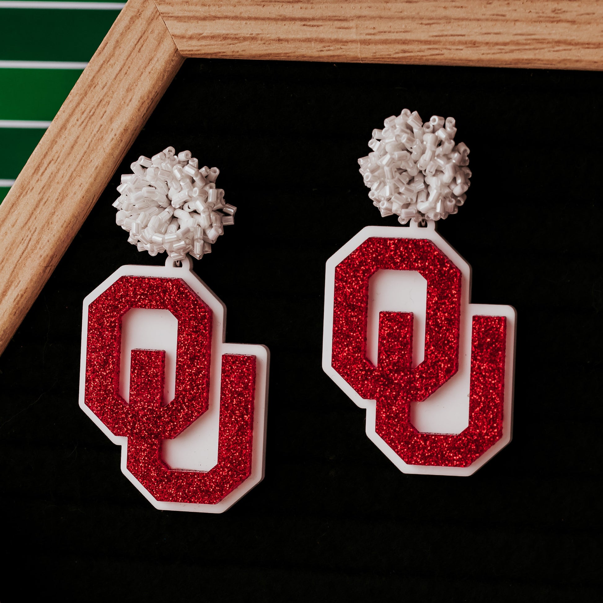 Officially licensed University of Oklahoma game day earring collection by Half Turn Designs. These earrings are available in combinations of crimson and white acrylic, including glitter. Available in a eight different fun toppers for OU game days and as a gift for your favorite Oklahoma Sooner. Crimson Glitter on White with White Beaded Toppers shown here.