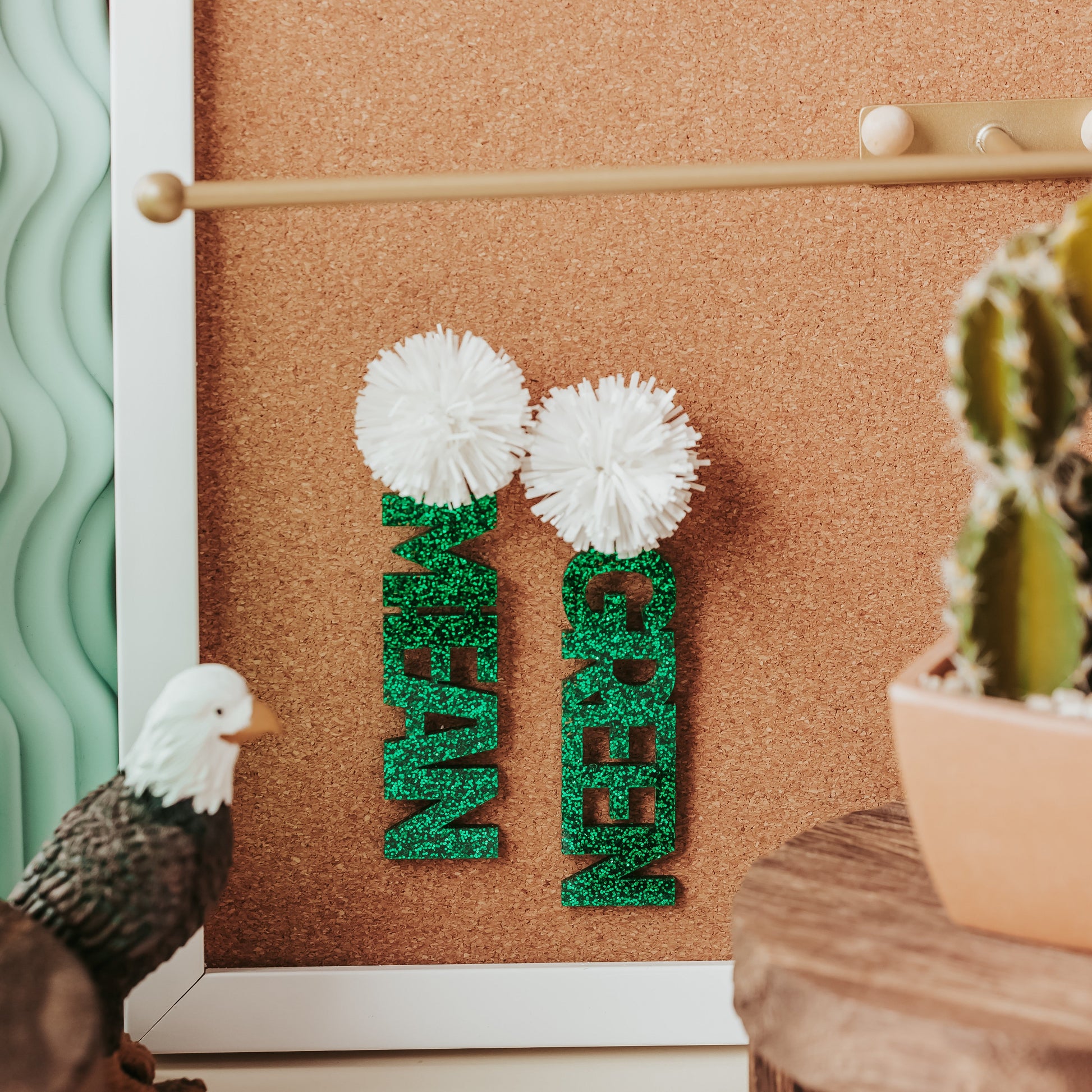 Officially licensed University of North Texas Mean Green Game Day earrings in green and white glitter with your choice of earrings topper including silver earring hooks, rhinestone topper, white tube bead topper, green tinsel topper, iridescent tinsel topper or white tinsel topper.  Mean and Green earrings shown here in green glitter with white tinsel earring topper