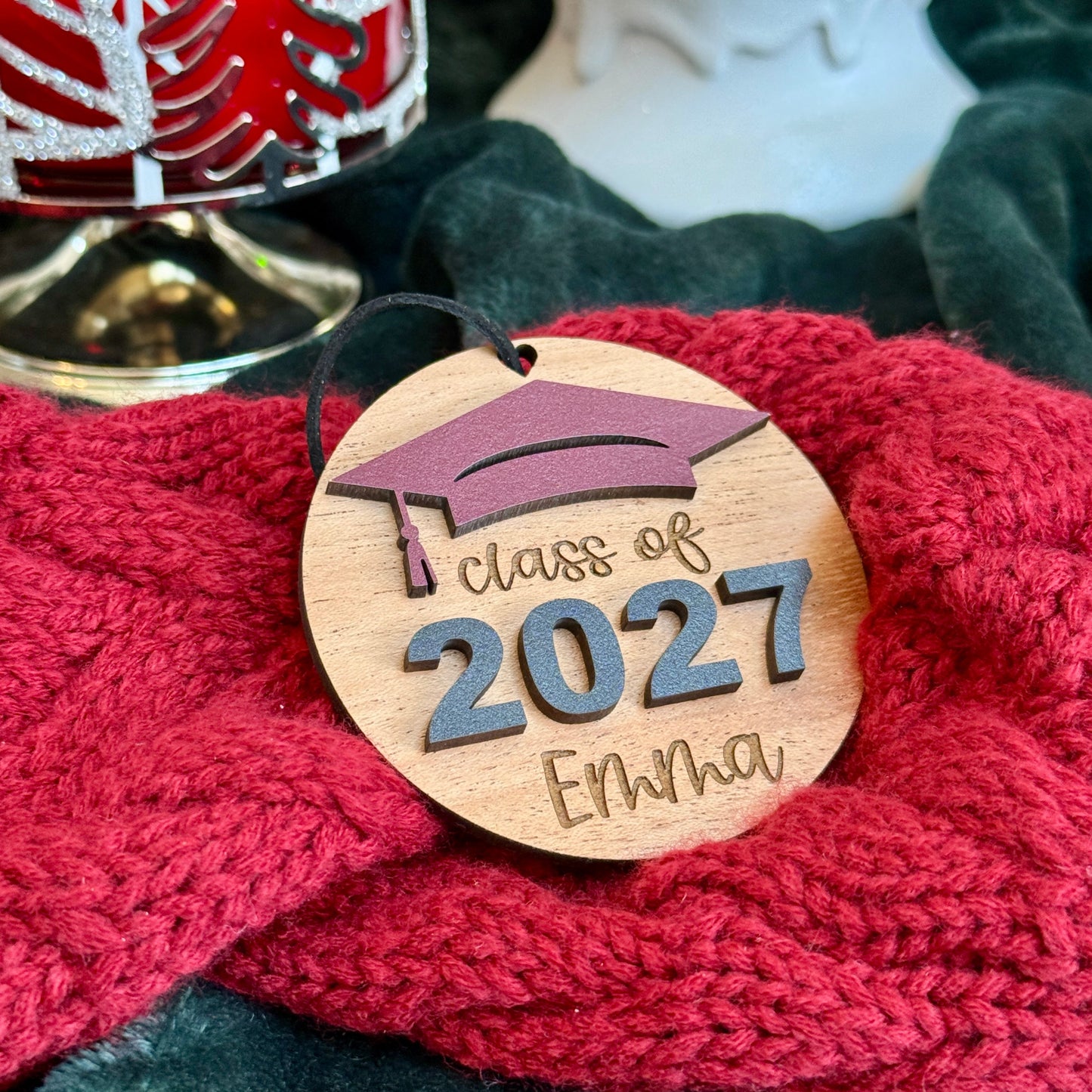 Class of 2027 wooden ornament in mahogany finish with marooon graduation cap, raised black 2027 numbers and graduate's engraved name