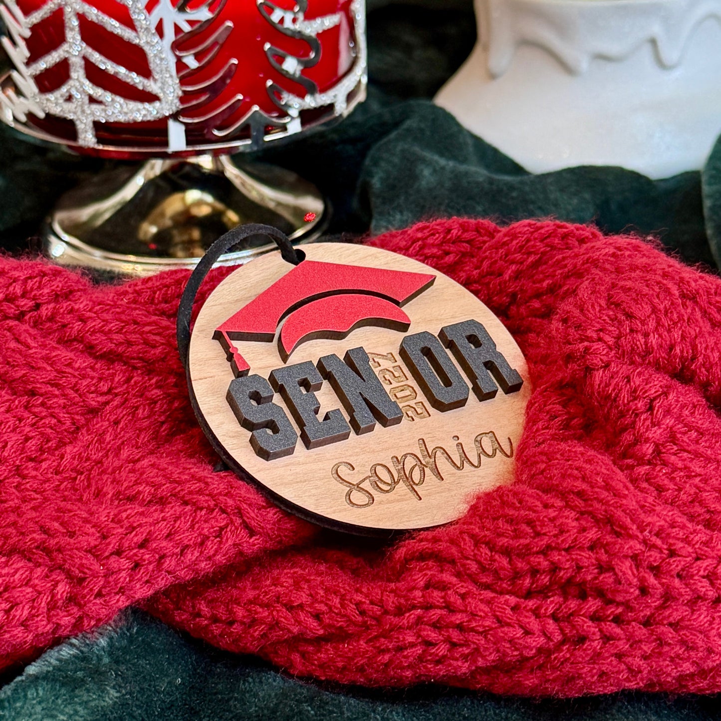 Personalized Senior 2027 wooden ornament in cherry wood finish with red graduation cap, engraved with the graduate's name