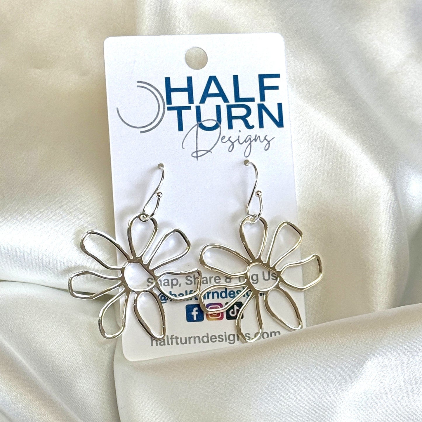 Silver daisy earrings on Half Turn Designs earring card 