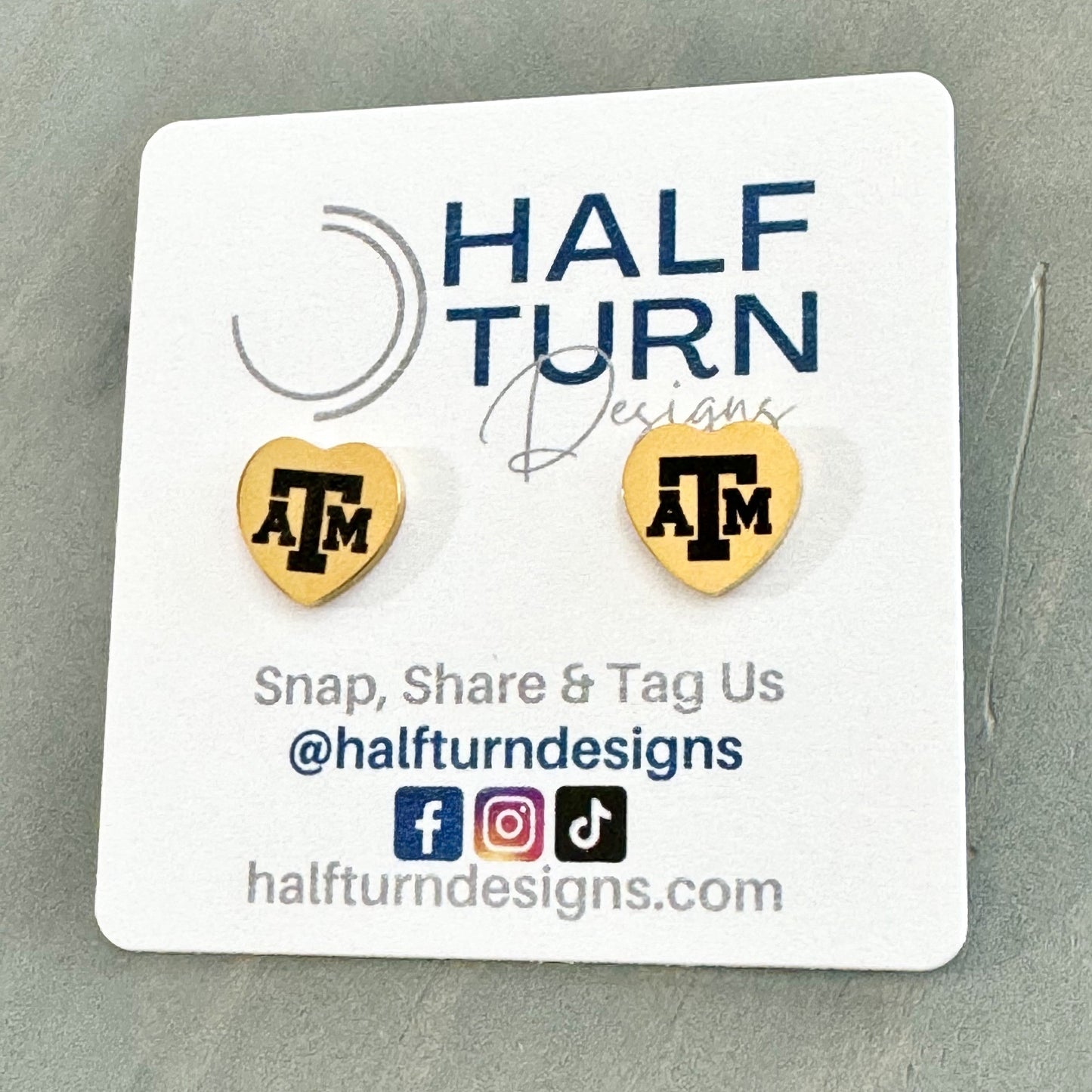 Heart-Shaped Texas A&M Stainless Steel Earring Studs engraved with the Texas A&M logo in gold or silver finish by Half Turn Designs, officially licensed with Texas A&M University.