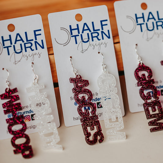 Texas A&M University mini mix & match dangles earrings in maroon and white glitter.  Phrases available include aggies, gig 'em, howdy and whoop
