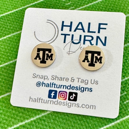 Texas A&M stud earrings engraved with the TAMU logo. The handmade earrings by Half Turn Designs are circular, 12mm in size and made from hypoallergenic Stainless Steel. Shown here in silver finish.