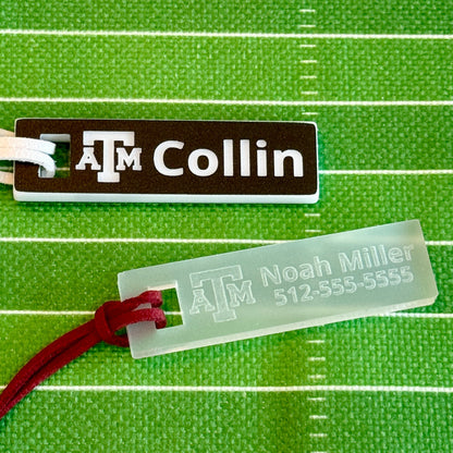 Officially licensed Texas A&M luggage and bag tags in rectangular shape, measuring 2.75x0.75".  These acrylic luggage and bag tags are personalized with 1-2 lines of text and come in 1/8" or 1/4" width.  Luggage tag colors include Clear, Frosted, Opaque Black, Shiny Black, Maroon that engraves white and Black that engraves white. Black that engraves white and frosted options shown here