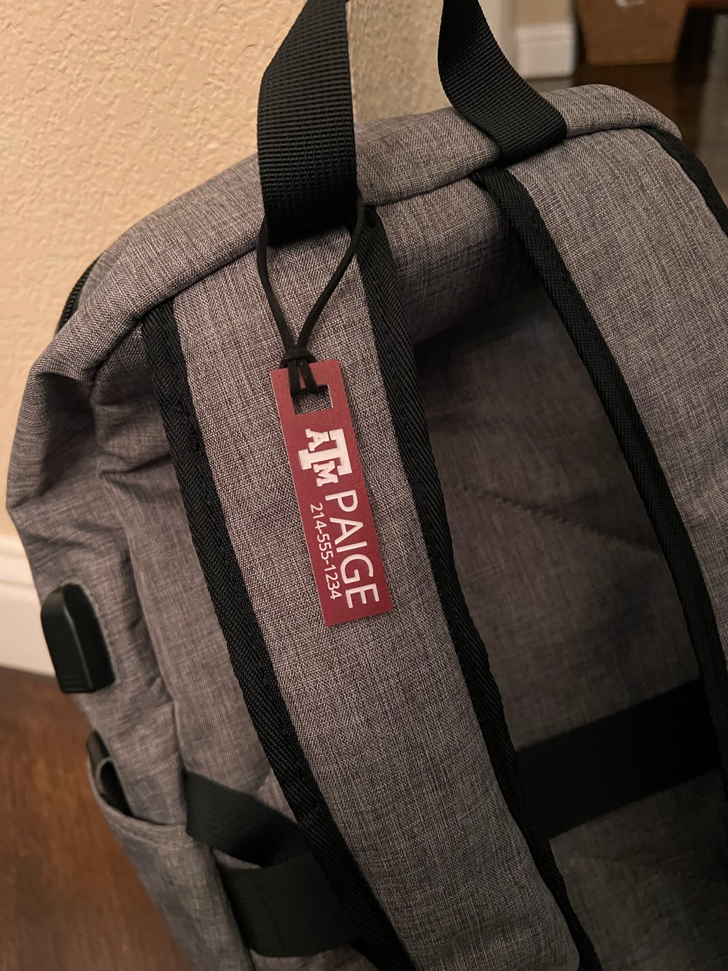 Officially licensed Texas A&M luggage and bag tags in rectangular shape, measuring 2.75x0.75".  These acrylic luggage and bag tags are personalized with 1-2 lines of text and come in 1/8" or 1/4" width.  Luggage tag colors include Clear, Frosted, Opaque Black, Shiny Black, Maroon that engraves white and Black that engraves white.  Maroon that engraves white shown here fastened to a backpack