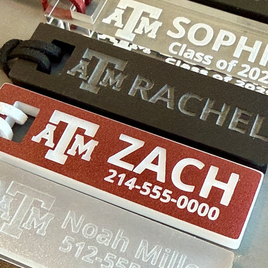 Officially licensed Texas A&M luggage and bag tags in rectangular shape, measuring 2.75x0.75".  These acrylic luggage and bag tags are personalized with 1-2 lines of text and come in 1/8" or 1/4" width.  Luggage tag colors include Clear, Frosted, Opaque Black, Shiny Black, Maroon that engraves white and Black that engraves white.