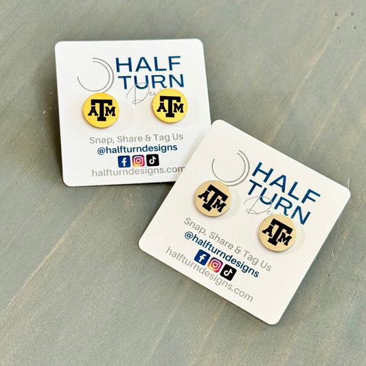 Texas A&M stud earrings engraved with the TAMU logo. The handmade earrings by Half Turn Designs are circular, 12mm in size and made from hypoallergenic Stainless Steel in gold or silver finish.