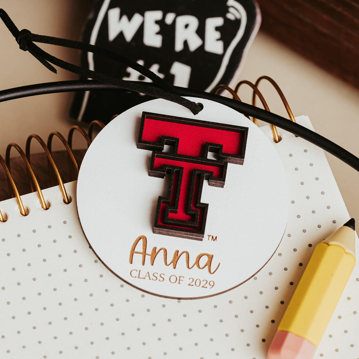 White Texas Tech ornament with a black cord, personalized with the name Anna and Class of 2029. 