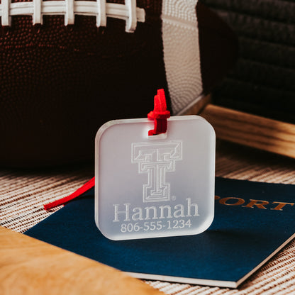 Officially Licensed Texas Tech University luggage tags featuring the TTU logo, personalized with customer's choice of 1-3 lines of information. Available in Clear, Frosted and Opaque Black acrylic by Half Turn Designs.  Shown here in frosted acrylic.