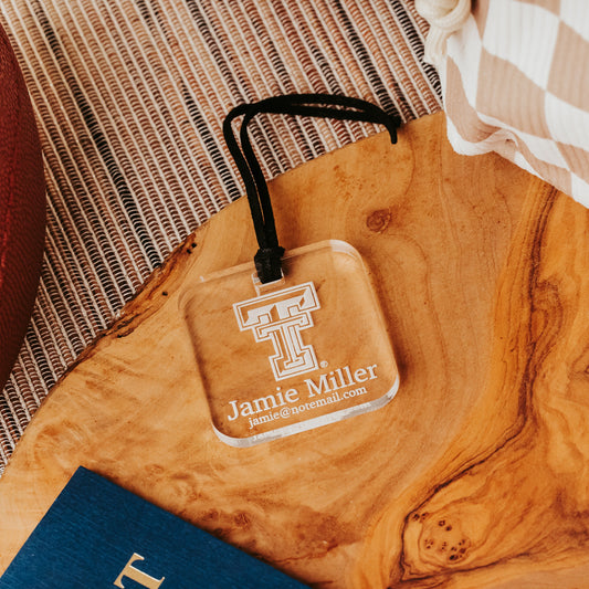 Officially Licensed Texas Tech University luggage tags featuring the TTU logo, personalized with customer's choice of 1-3 lines of information. Available in Clear, Frosted and Opaque Black acrylic by Half Turn Designs.  Shown here in clear acrylic.
