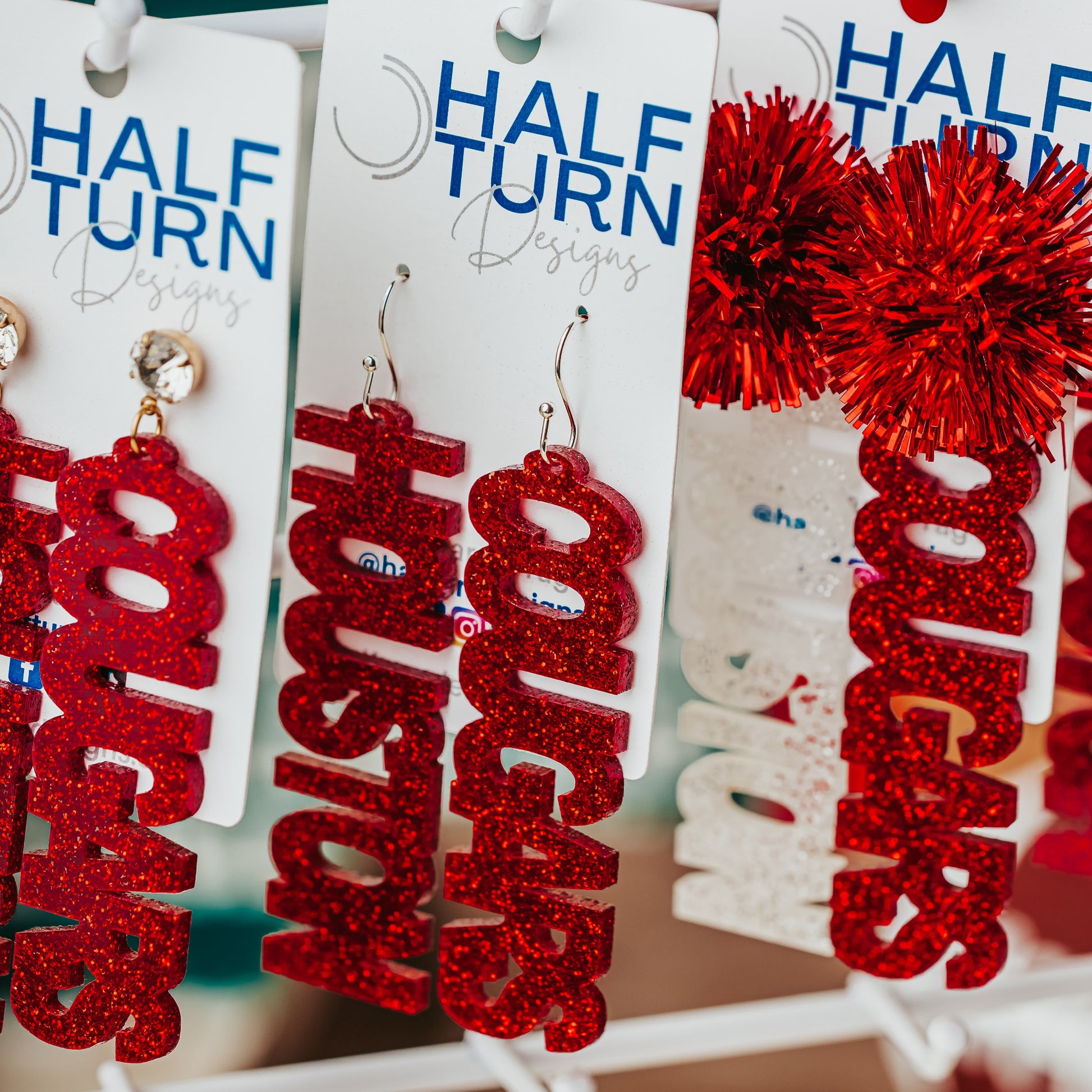 Officially Licensed University of Houston Cougars acrylic dangle earrings in red and white glitter with a variety of earring toppers including earring hooks, rhinestone and tinsel by Half Turn Designs.
