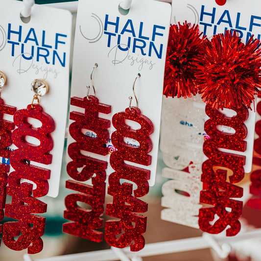 Officially Licensed University of Houston Cougars acrylic dangle earrings in red and white glitter with a variety of earring toppers including earring hooks, rhinestone and tinsel by Half Turn Designs.