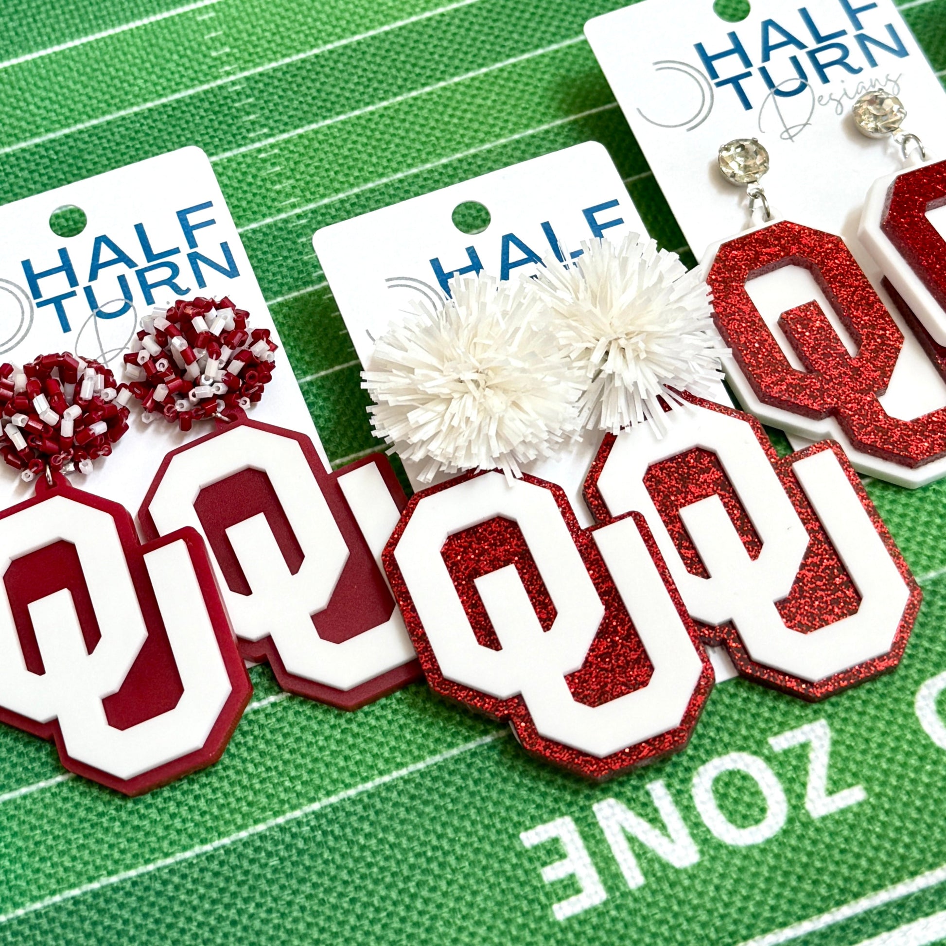 Officially licensed University of Oklahoma game day earring collection by Half Turn Designs. These earrings are available in combinations of crimson and white acrylic, including glitter. Available in a eight different fun toppers for OU game days and as a gift for your favorite Oklahoma Sooner.